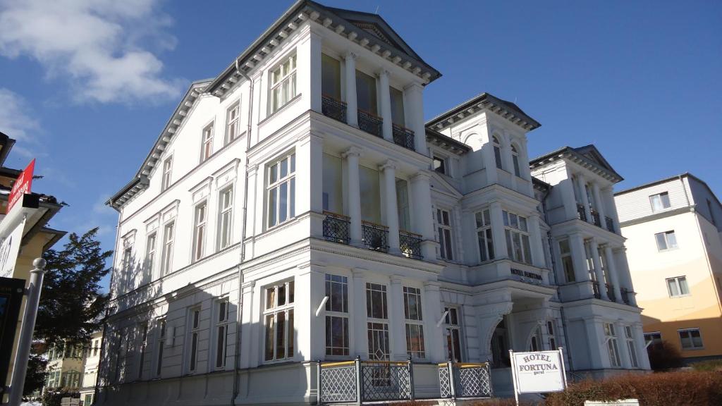 a large white building with a clock on it at Hotel Fortuna in Heringsdorf