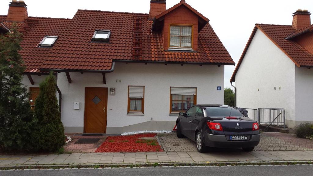 une voiture noire garée devant une maison dans l'établissement Villa Mahnberg, à Rödental