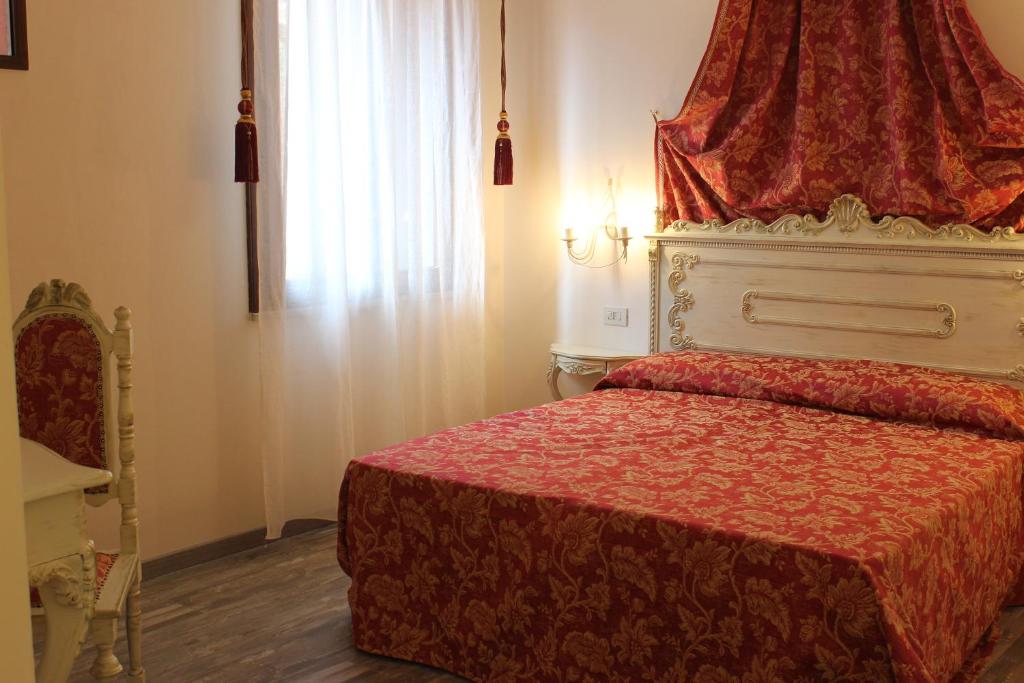 a bedroom with a red bed with a red canopy at Albergo Al Castello in Recoaro Terme