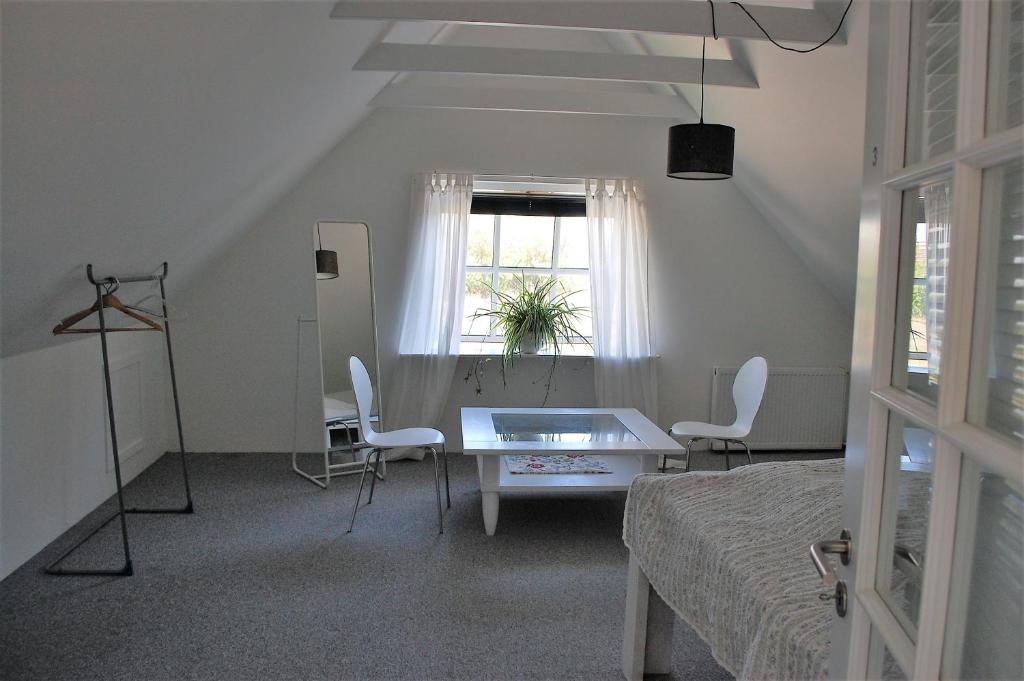 フレデンスボーにあるFredensborg Guesthouseのベッドルーム1室(ベッド1台、テーブル、椅子付)