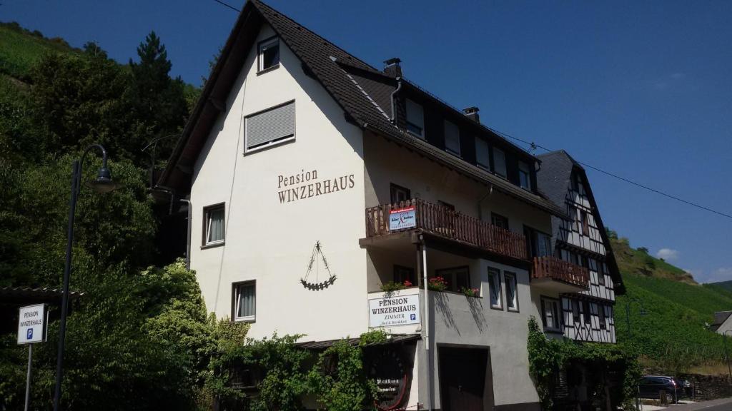 a white building with a sign on the side of it at Hotel Pension Winzerhaus in Bacharach