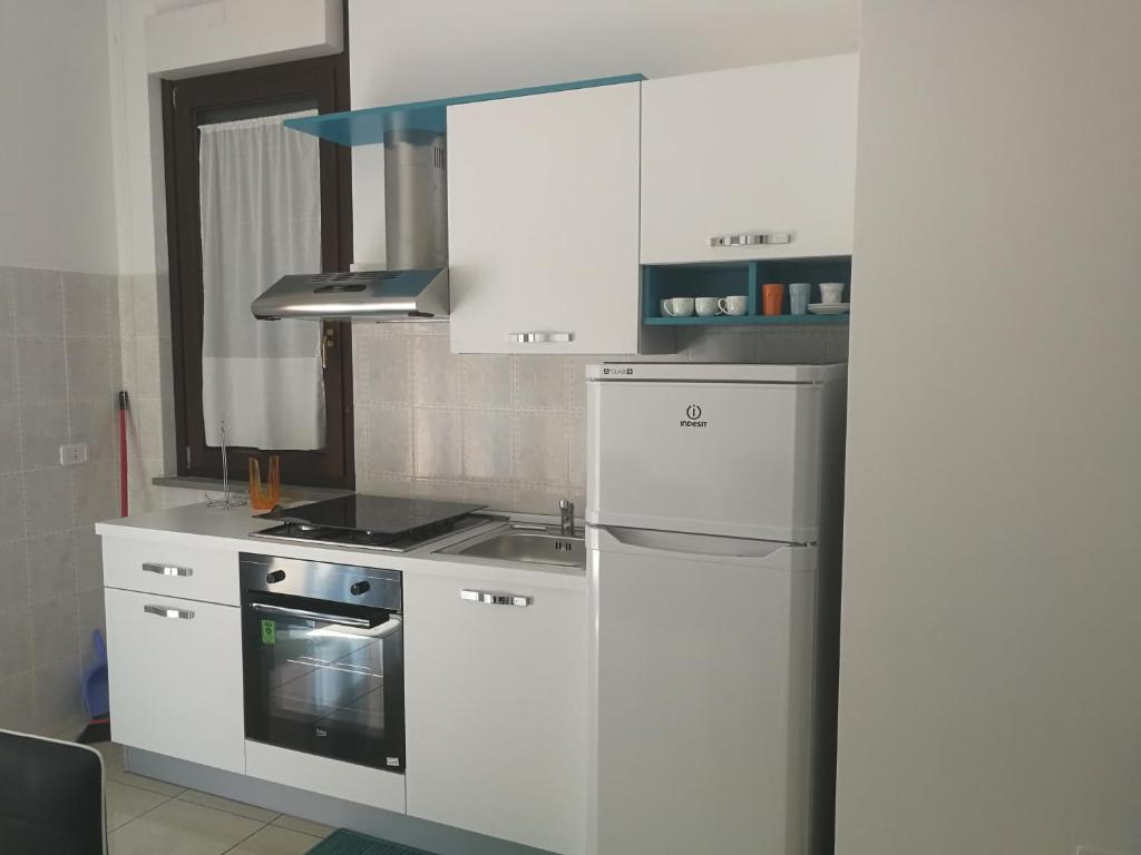 a white kitchen with a stove and a refrigerator at Confortable Apartment in Vasto in Vasto