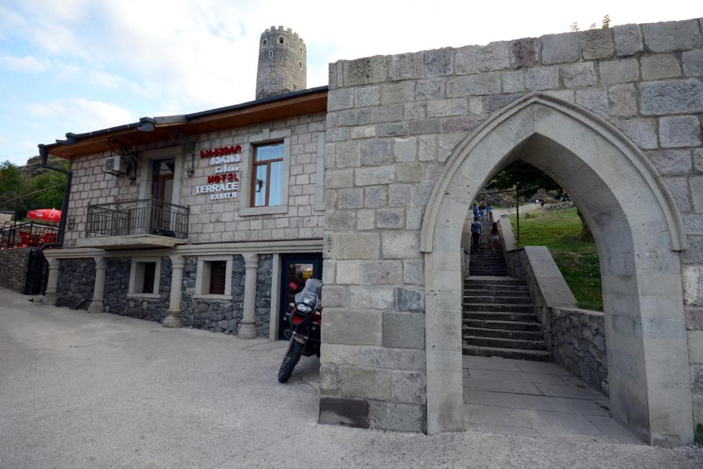 a stone building with a motorcycle parked in front of it at Hotel Terrace Rabath in Akhaltsikhe