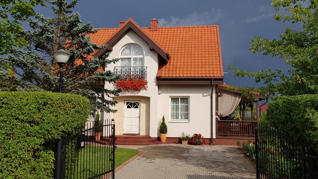 una casa blanca con techo naranja en Vila Joana en Palanga