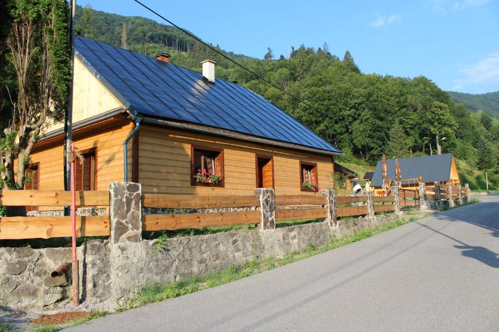 a wooden house with a fence next to a road at Chata u Petrenkov in Horná Turecká