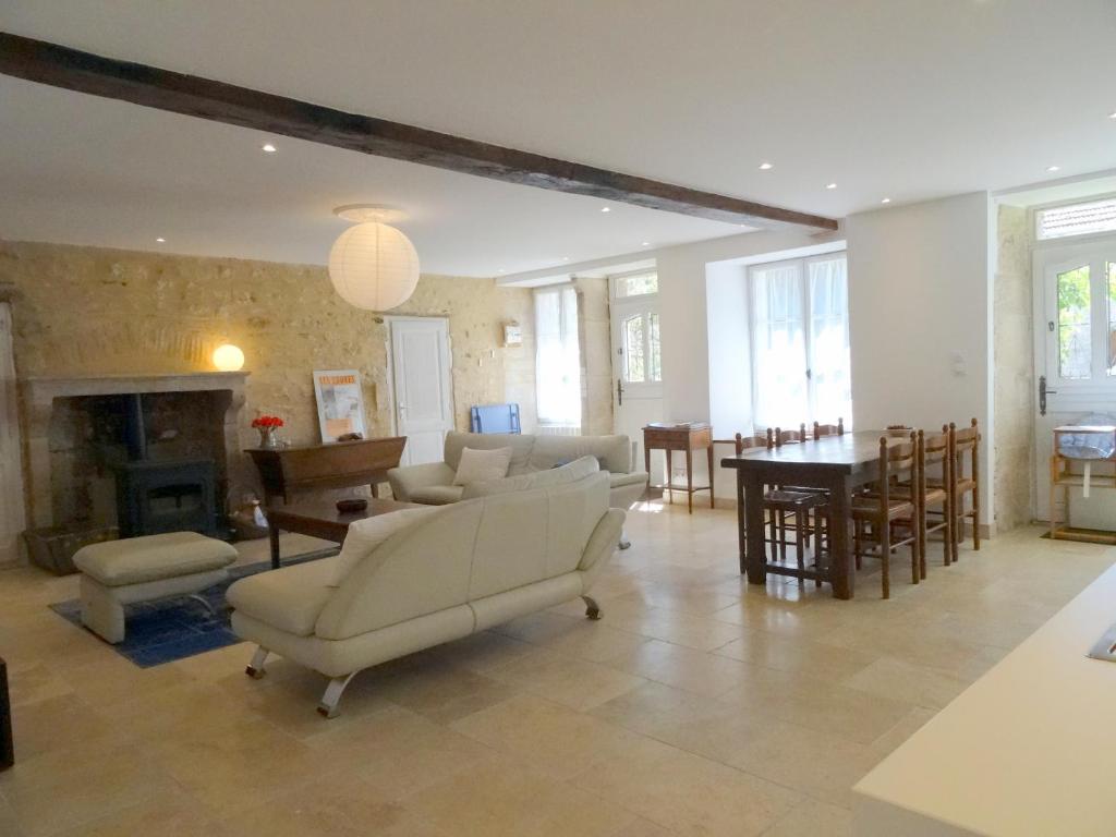 ein Wohnzimmer mit Sofas, einem Tisch und einem Esszimmer in der Unterkunft La Cour in Flavigny-sur-Ozerain