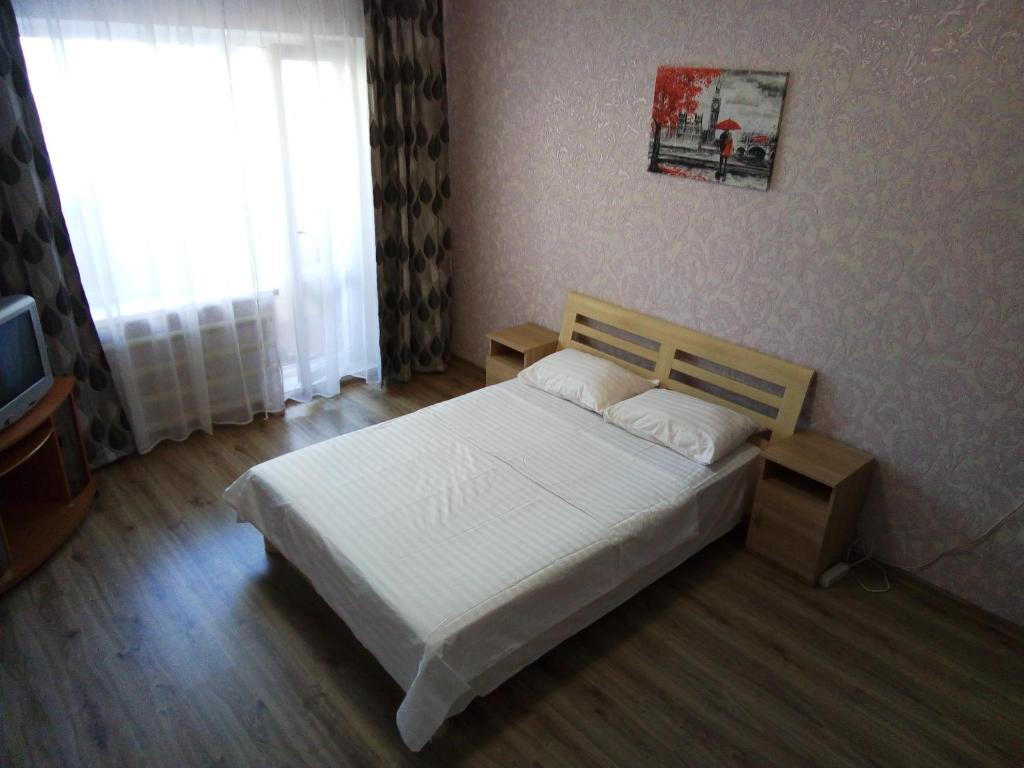 - une chambre avec un lit blanc et une fenêtre dans l'établissement Apartment on Kharkovskoe Shosse 170 b, à Kiev
