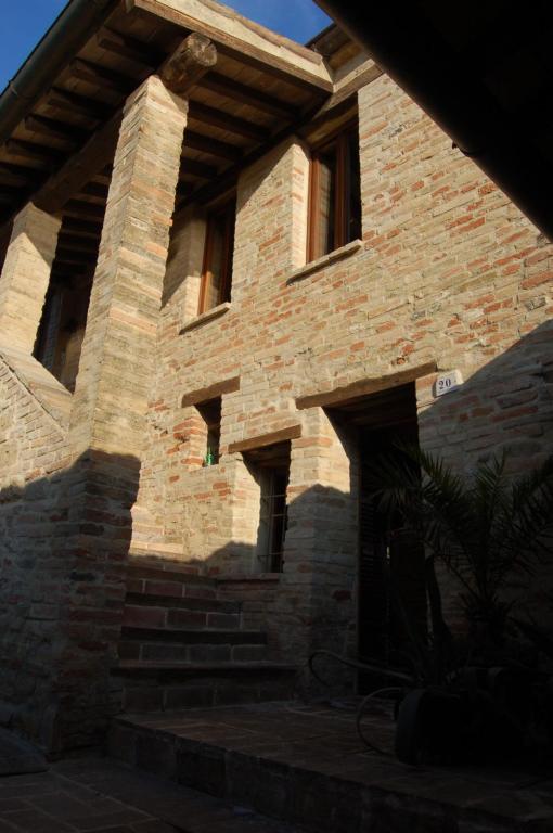 um edifício de tijolos com escadas em frente em Il Poggio em Mombaroccio