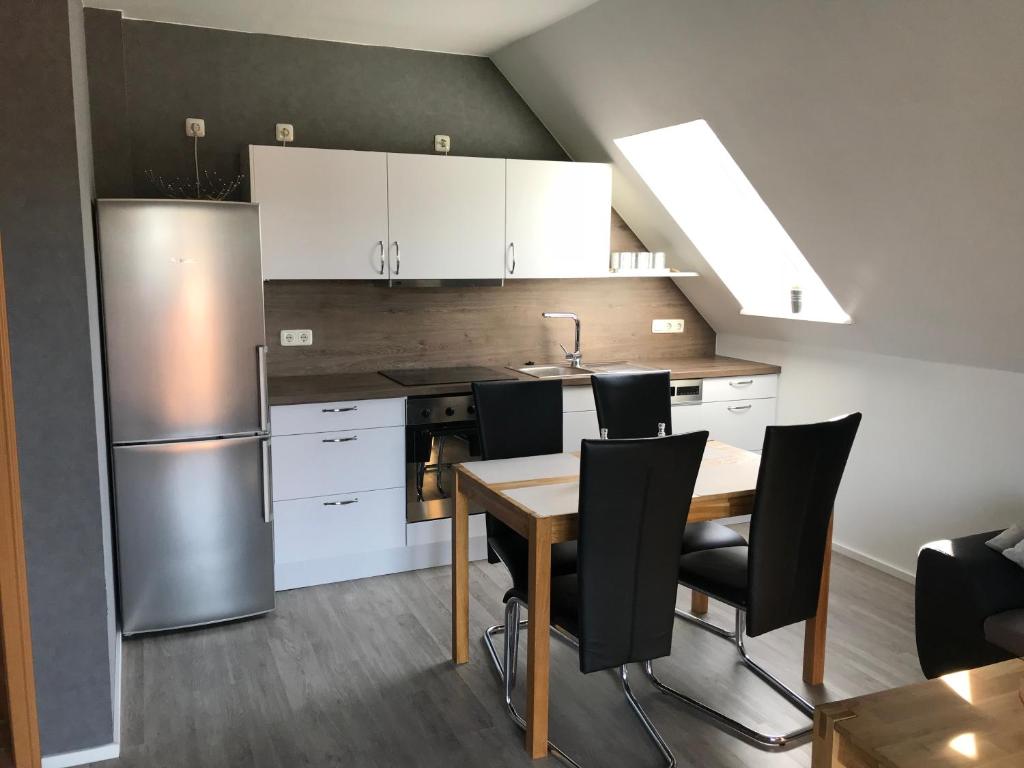 a kitchen with a table and a stainless steel refrigerator at Ferienwohnung Wansiedler in Sankt Peter-Ording