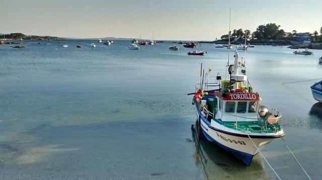 a boat is docked in a body of water at Tu Piso en la Playa in Villanueva de Arosa