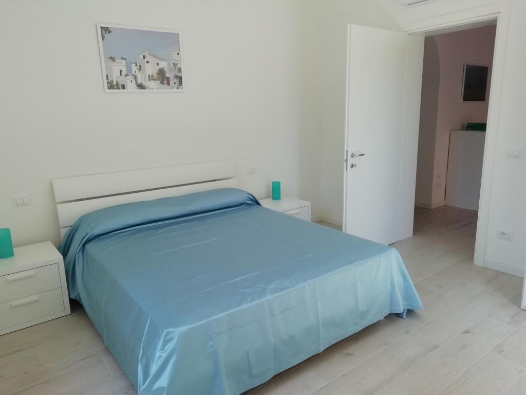 sypialnia z niebieskim łóżkiem w białym pokoju w obiekcie Via Cipro 16 w Lido di Venezia