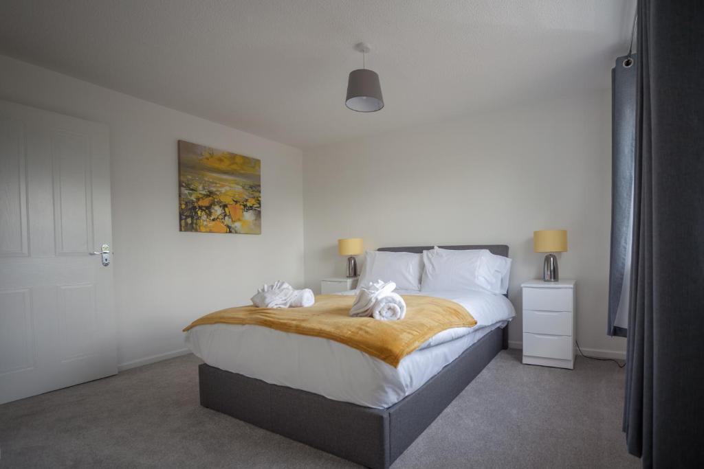 a bedroom with a large bed with towels on it at Kestrel House by RentMyHouse in Hereford