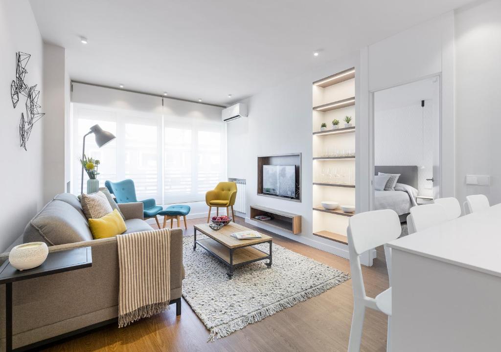 a living room with a couch and a table at Francisco Silvela Apartment by Flatsweethome in Madrid