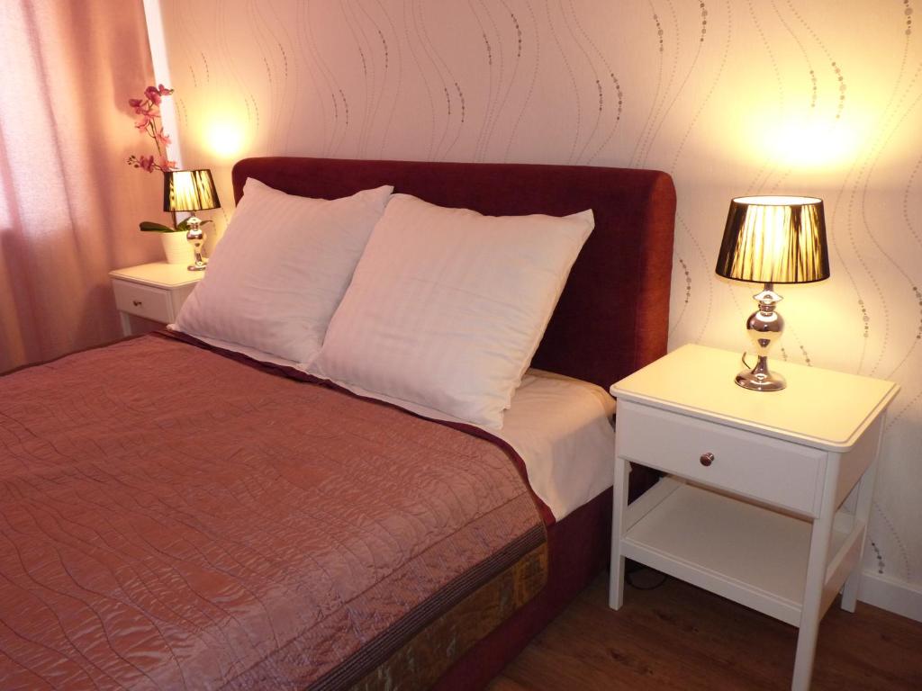 ザモシチにあるApartament Heveliusのベッドルーム1室(ベッド1台、ナイトスタンド2台、ランプ2つ付)
