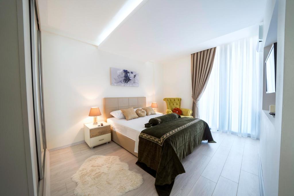 een witte slaapkamer met een bed en een raam bij Karia Plus City Apartments in Kyrenia