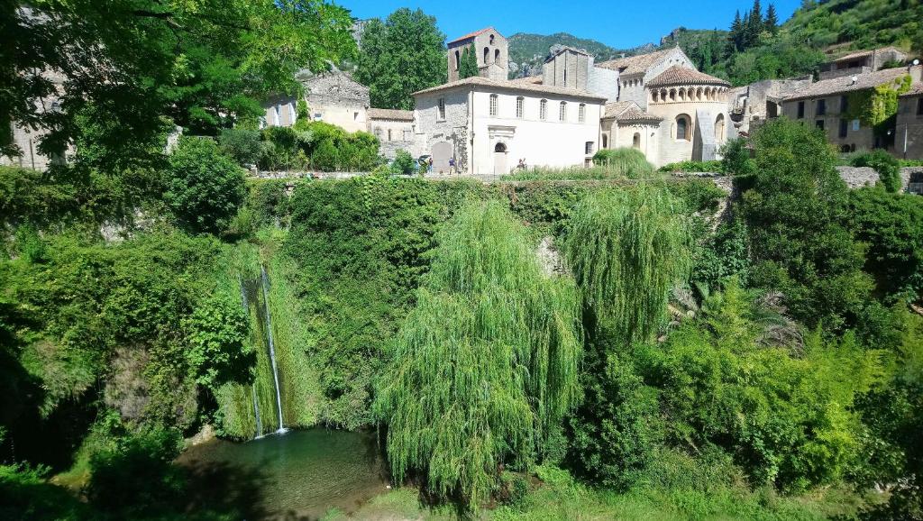 a view of a village with a waterfall in a river at Gîte de La Tour in Saint-Guilhem-le-Désert