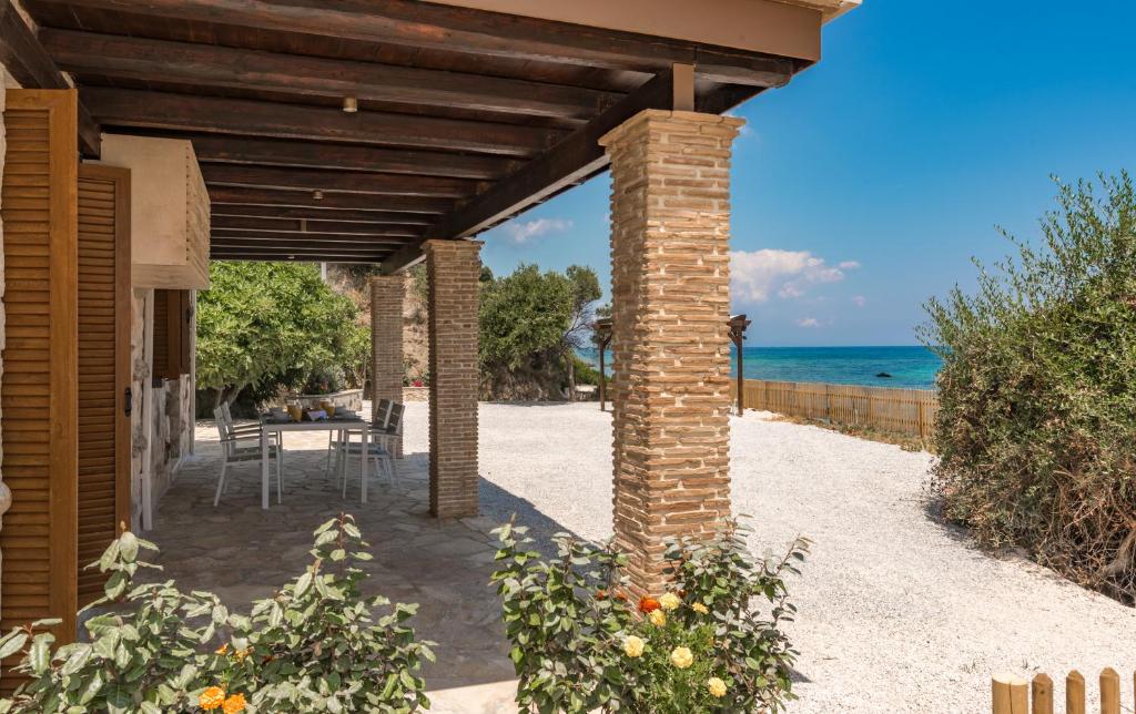a brick pergola with a table and the ocean at Villa Julia in Zakynthos Town