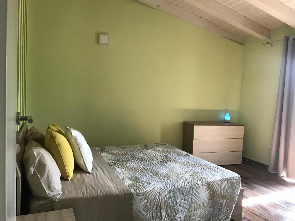 una camera da letto con letto e cuscini gialli di zagare dell'etna a Giarre