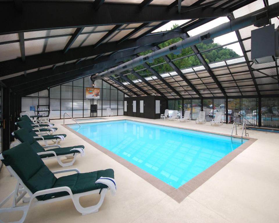 a large swimming pool with lounge chairs in a building at Black Bear Inn & Suites in Gatlinburg