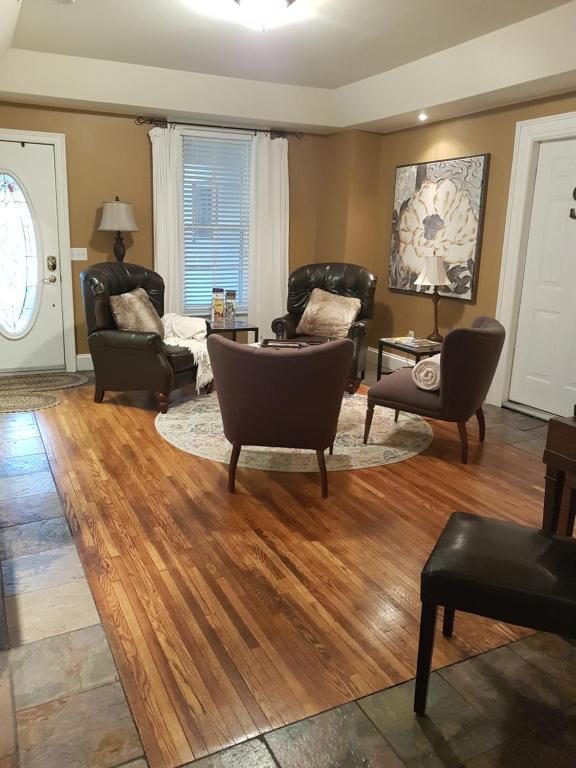 a living room with leather furniture and wooden floors at Hellemsfield Inn & bed and breakfast in Kingsville