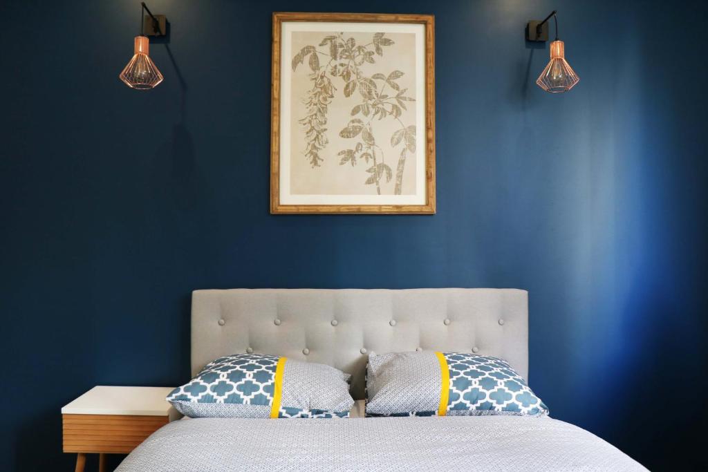 アニエール・シュル・セーヌにあるStayLib - NICE FLAT 2 ROOMSの青い壁のベッドルーム1室、ベッド1台(枕2つ付)