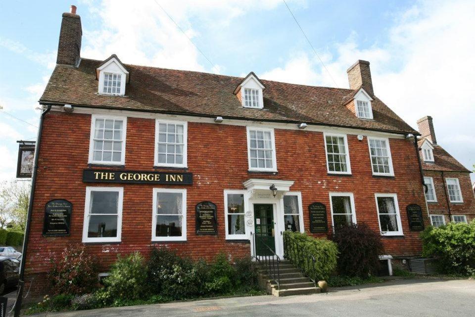 a red brick building with the fireplace inn at The George Inn in Robertsbridge