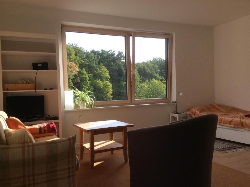 a living room with a large window and a table at Haus am Wald in Waldbrunn