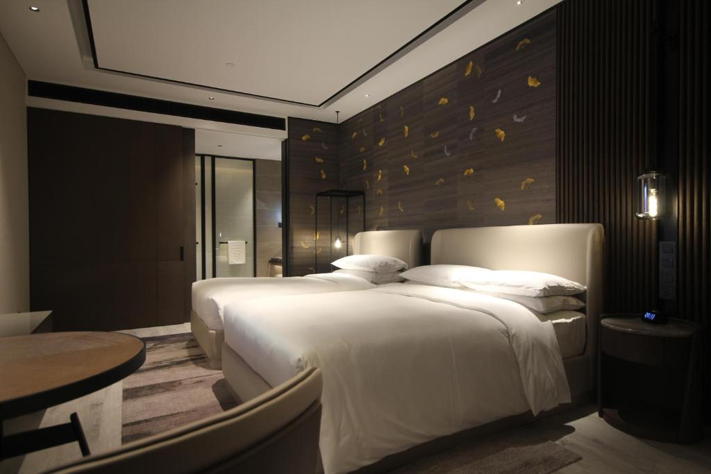 Postel nebo postele na pokoji v ubytování Yunhe Yebo Hotel (Shanghai International Tourism Resort Pudong Airport)