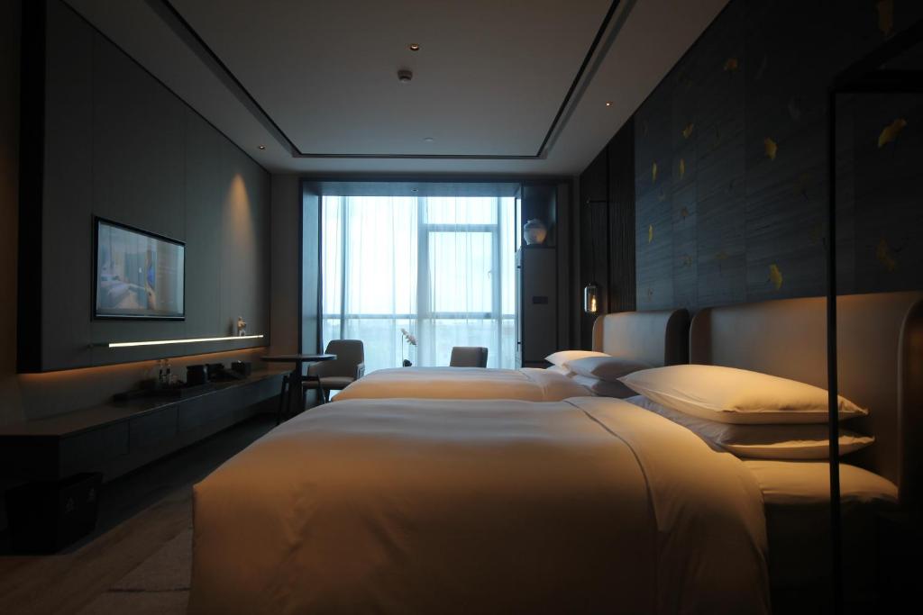 Postel nebo postele na pokoji v ubytování Yunhe Yebo Hotel (Shanghai International Tourism Resort Pudong Airport)