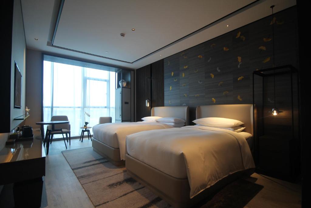 Postel nebo postele na pokoji v ubytování Yunhe Yebo Hotel (Shanghai International Tourism Resort Pudong Airport)