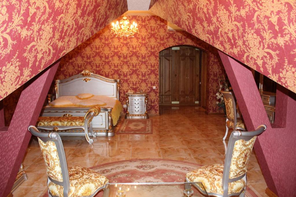 a bedroom with a bed and two chairs at Ceasar in Mykolaiv