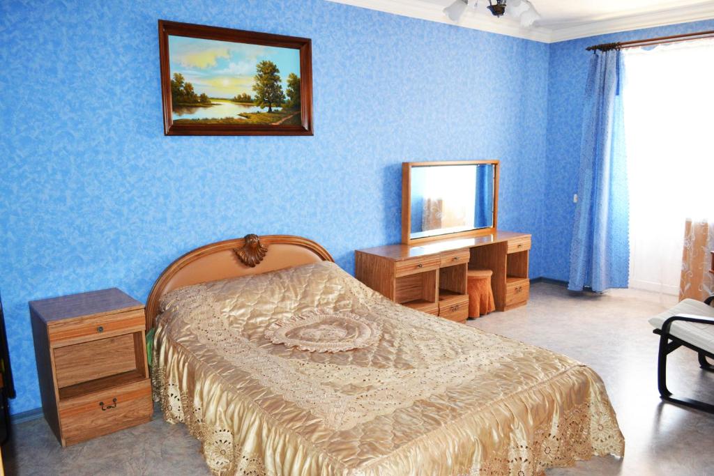 シャフティにあるУютная 1-квартира в центре городаの青い壁のベッドルーム(ベッド1台、鏡付)