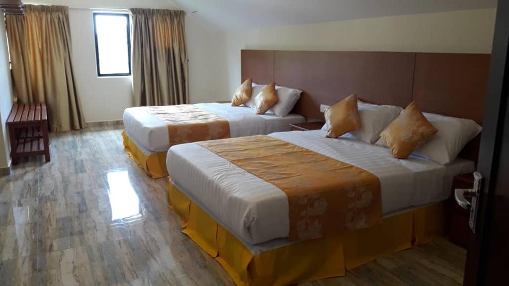金馬崙高原的住宿－鬱金香公寓式酒店，一间酒店客房,房间内设有两张床