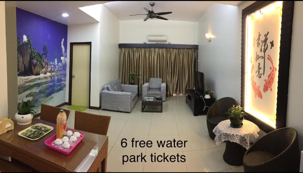 Homestay at Lagoon Park Resort في ميلاكا: غرفة معيشة مع طاولة وكراسي وغرفة معيشة مع طاولة طعام