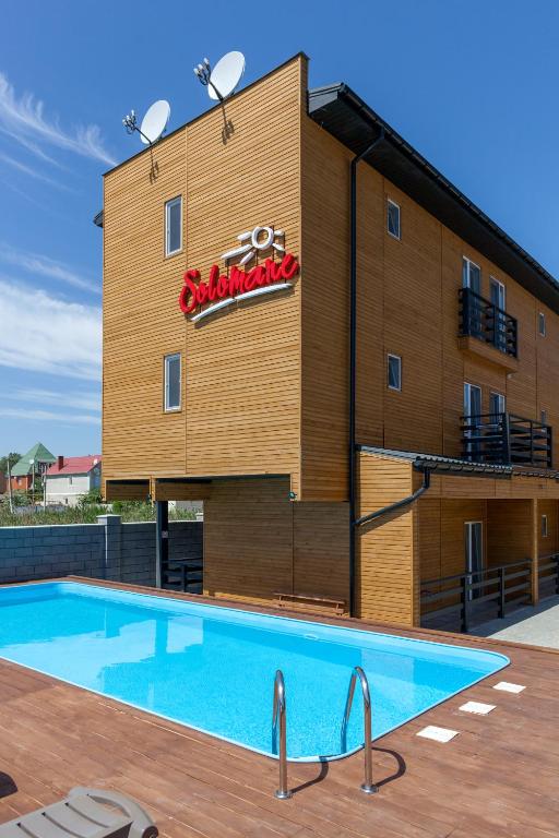 a hotel with a swimming pool in front of a building at Villa Solomare in Zatoka