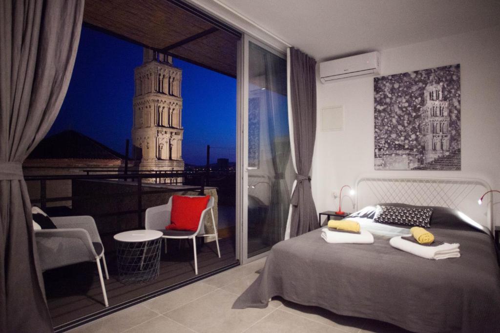 Schlafzimmer mit einem Bett und Blick auf einen Turm in der Unterkunft Studiolo Belvedere in Split
