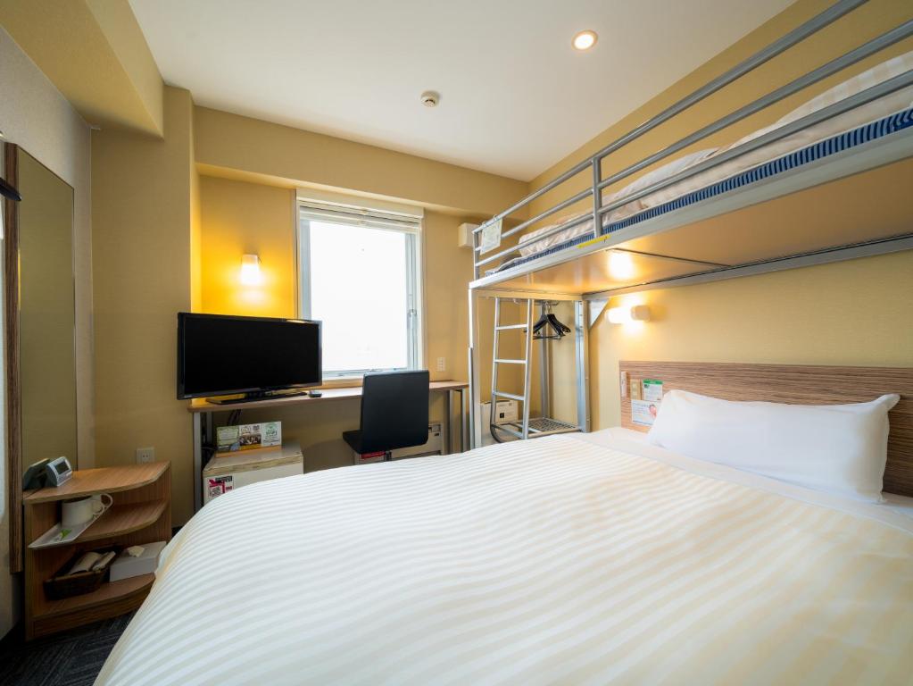 Super Hotel Hirosaki في هيروساكي: غرفة نوم مع سرير وسرير بطابقين