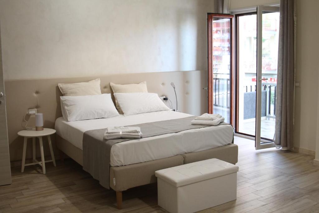 um quarto com uma grande cama branca e uma mesa em Michelangelo Home B&B em Rossano