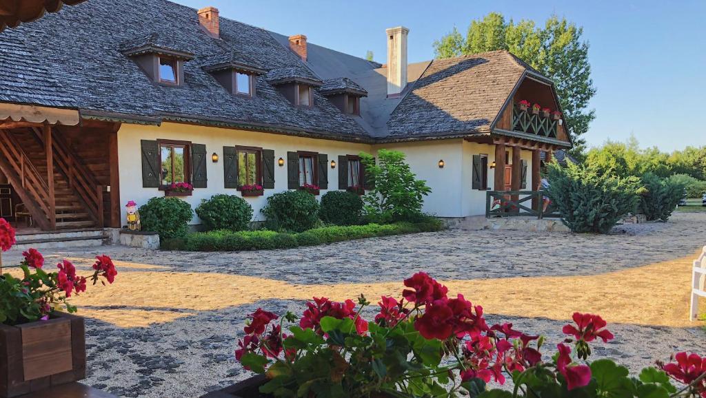 uma casa com flores vermelhas em frente em Dworek Pod Wiechą em Kawęczyn