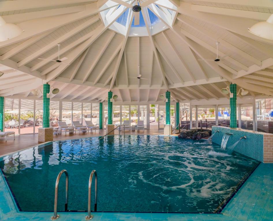 a swimming pool in a building with a ceiling at H10 Playa Esmeralda - Adults Only in Costa Calma