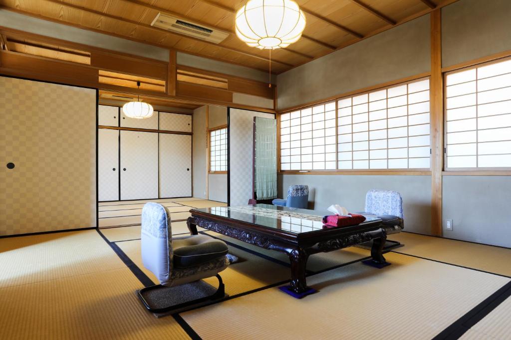 a room with a glass table and two chairs at Konuka Yakushi Temple House in Kyoto