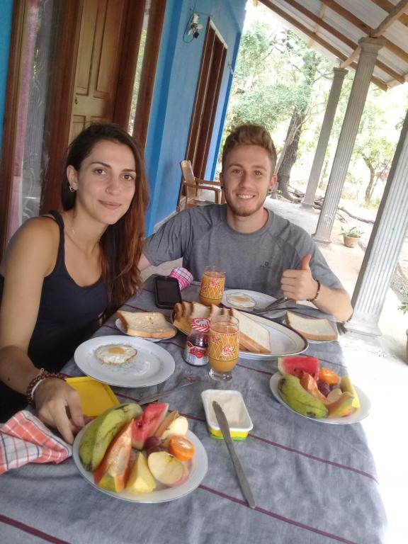 un hombre y una mujer sentados en una mesa con platos de comida en Dambulla Sun Vsh Holiday, en Dambulla
