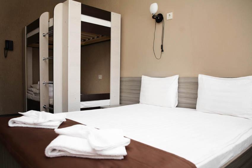 1 dormitorio con 1 cama blanca grande y toallas. en GagarInn Hotel, en Kazán