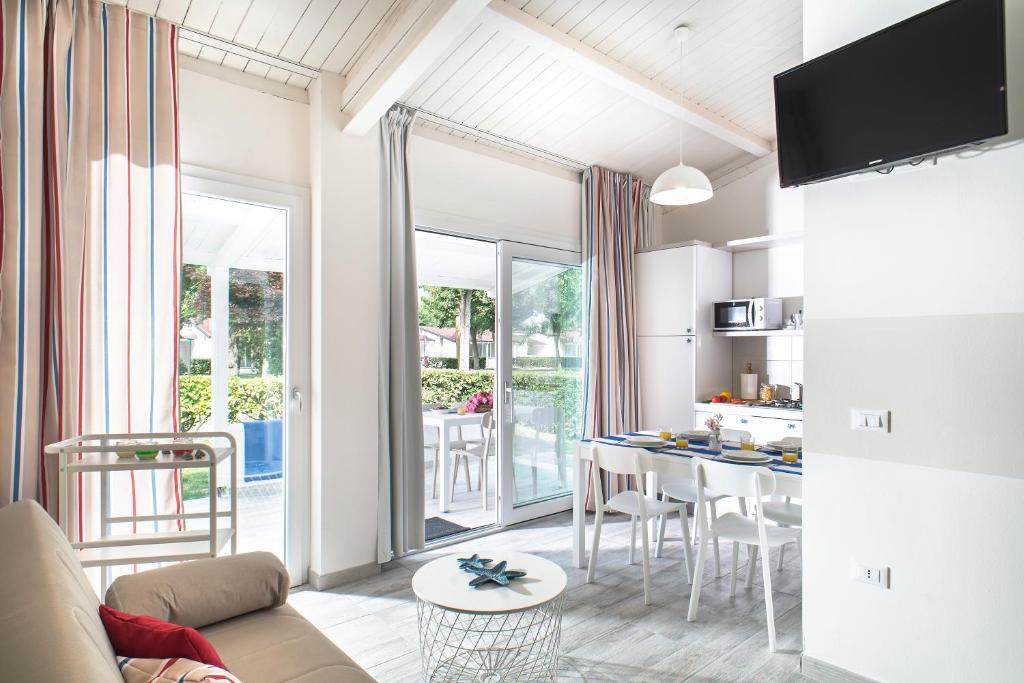 a living room with a couch and a table with chairs at Villaggio San Francesco in Duna Verde