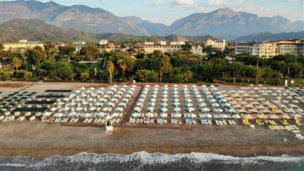 a large parking lot with white umbrellas on the beach at Lucida Beach - All Inclusive in Kemer