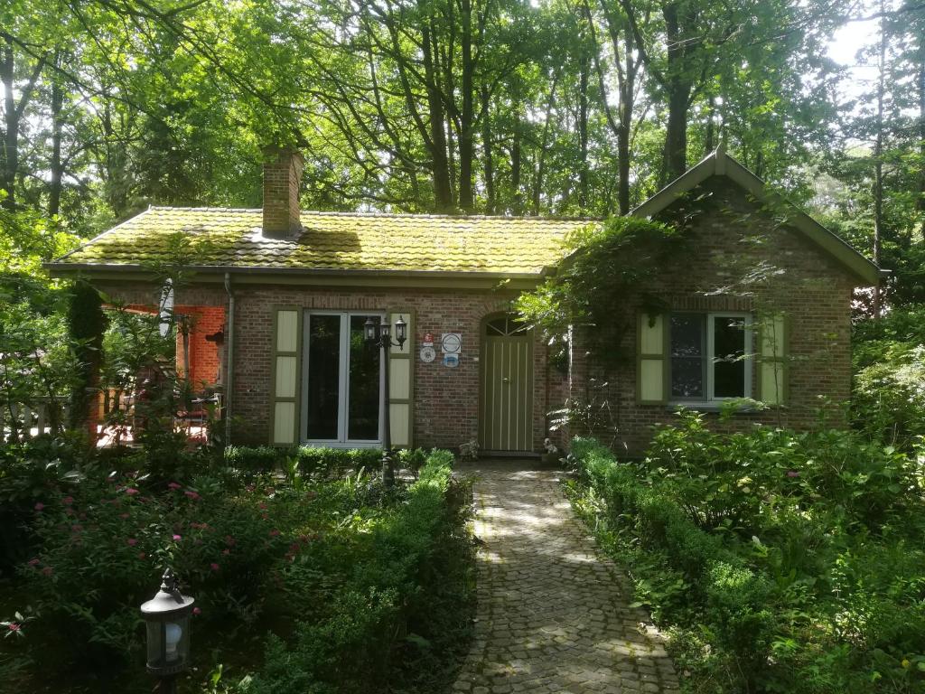 una pequeña casa de ladrillo con una puerta verde en Rainbow Lodge en Ursel