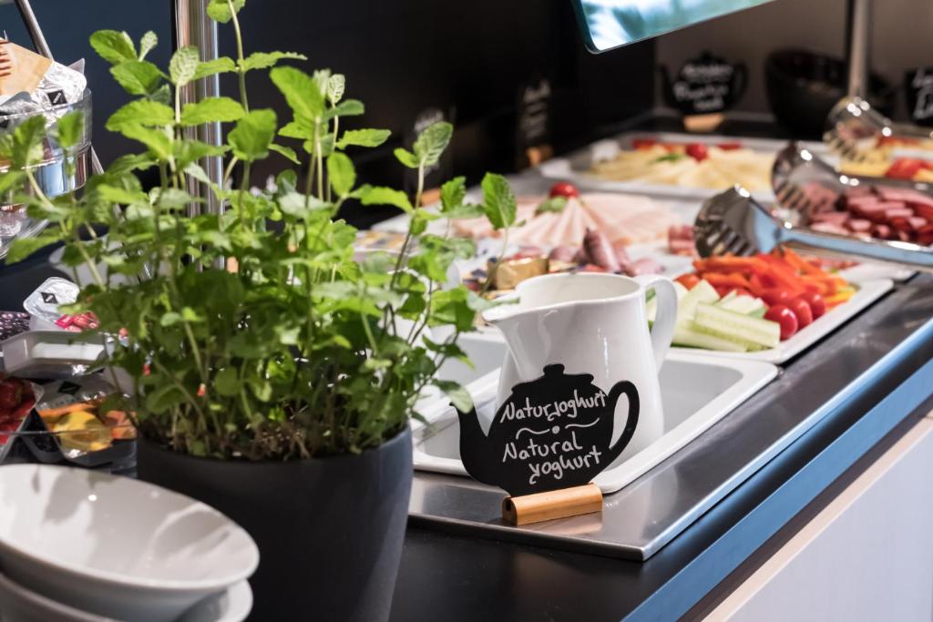 a buffet with plants and food on a table at Airbase Hotel in Kalsdorf bei Graz