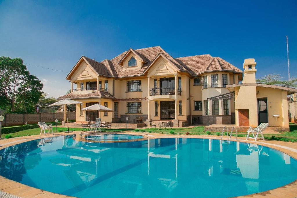 a large house with a swimming pool in front of it at Orchid Homes, Gigiri in Nairobi