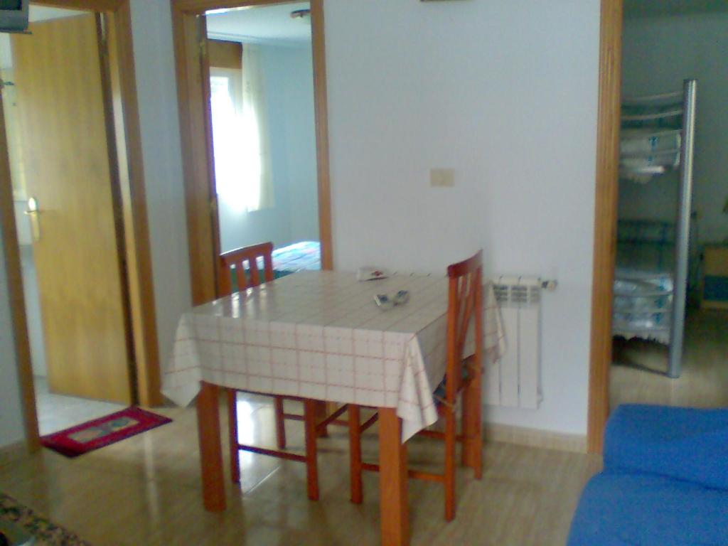 mesa de comedor y sillas con mantel blanco en Casa de la Abuela, en Bubaces