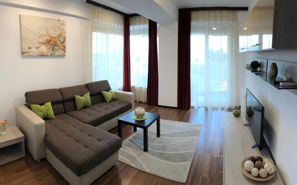 ママイアにあるAlcomar Apartment - Summerland Mamaiaのリビングルーム(ソファ、テーブル付)